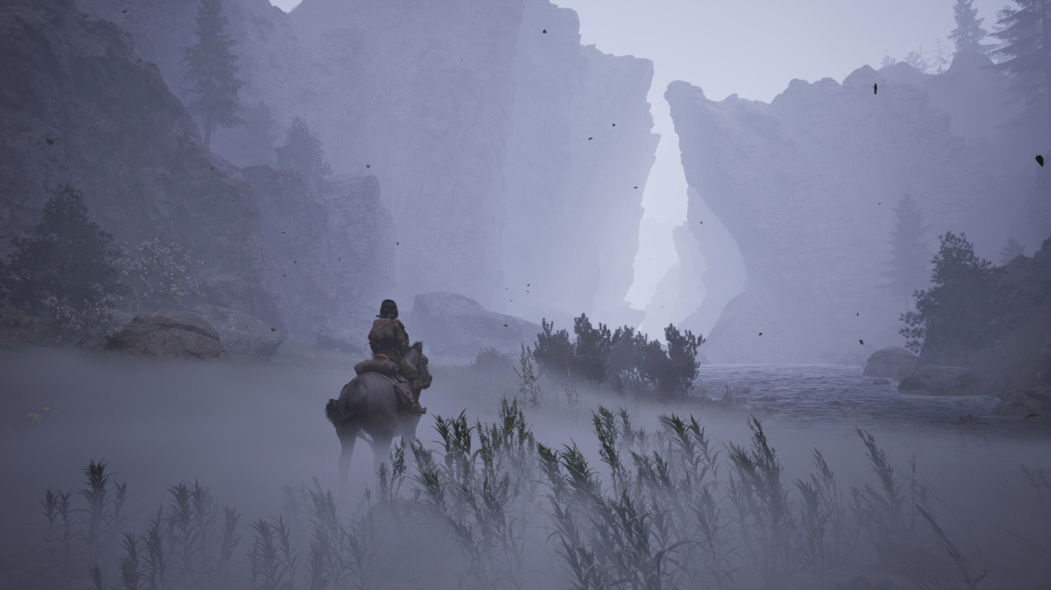 A rider on horseback crossing a misty river valley between cliffs